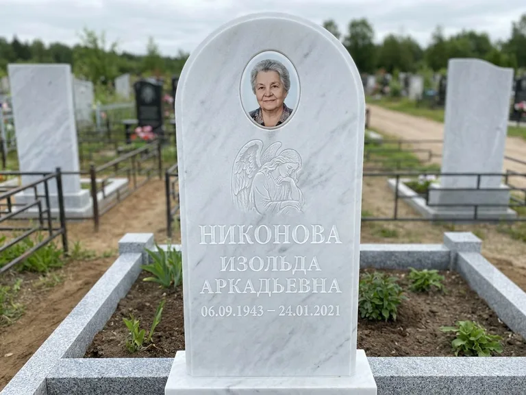 Памятник с гравировкой ангела — белая гравировка скорбящего ангела над портретом, работа «Гордеева» в Томске