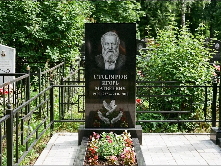 Памятник с гравировкой голубей — гравировка голубя над раскрытыми ладонями внизу стелы, работа «Столяров» в Томске