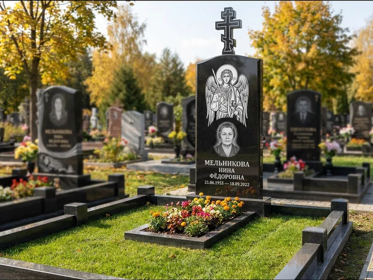 Памятник с гравировкой иконы: округлая стела-медальон с ликом — гравировка Богородицы «Семистрельная», луговые травы и полевые цветы за участком, работа «Гущин» в Томске