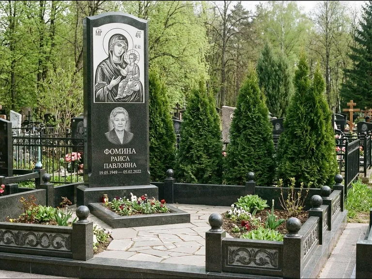 Памятник с гравировкой иконы: высокий гранёный обелиск с крестом-навершием — гравировка образа Матроны Московской, открытый участок без ограды, работа «Третьяков» в Томске