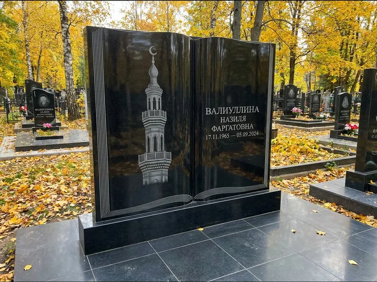 Мусульманский памятник с гравировкой мечети: стела в форме раскрытой книги на подставке — белая гравировка силуэта мечети с минаретами, цоколь тёмной плиткой, работа «Исмаилова» в Томске
