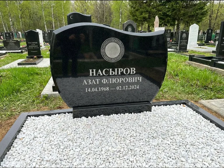 Мусульманский памятник: стела с волнообразным скошенным верхом — гравировка мечети под полумесяцем и звёздами, белая мраморная крошка с бордюром, работа «Насыров» в Томске