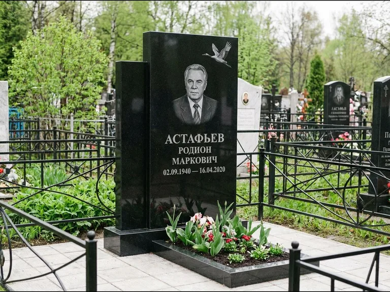 Памятник с гравировкой журавлей — гравировка одиночного летящего журавля над портретом, работа «Астафьев» в Томске