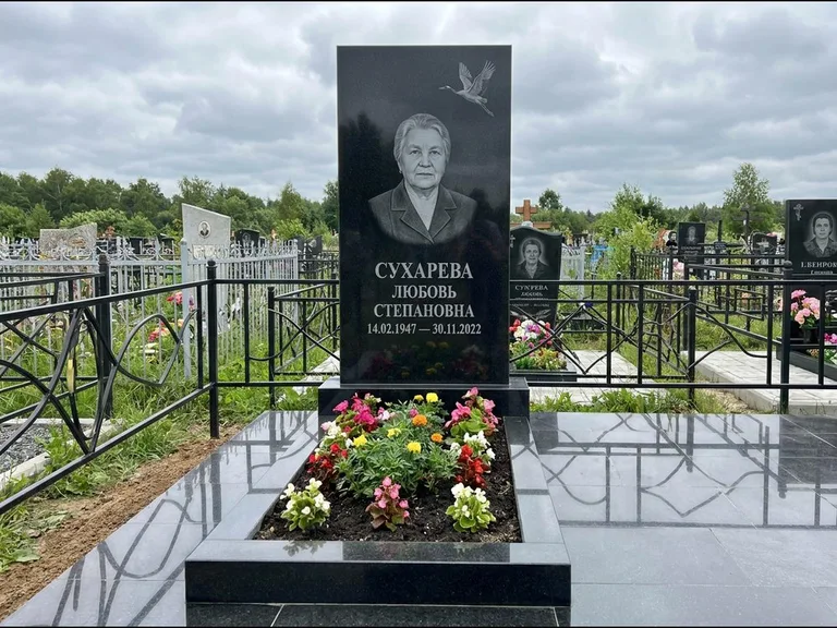 Памятник с гравировкой журавлей — гравировка одиночного летящего журавля над портретом, работа «Сухарева» в Томске