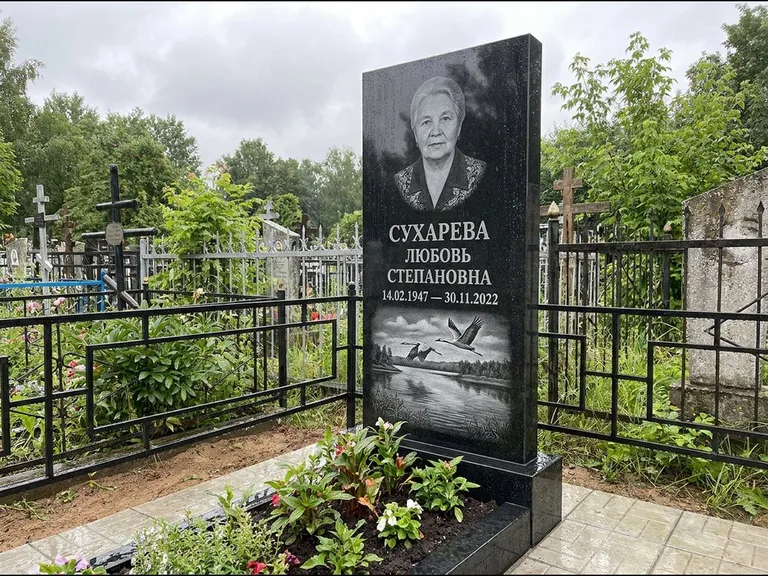 Памятник с гравировкой журавлей — гравировка пары журавлей над гладью озера в нижней части, работа «Сухарева» в Томске