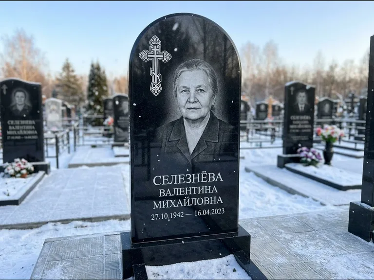 Памятник из чёрного гранита — массивная стела с крестом в лучах с крестом в лучах, работа «Одинцова» в Томске