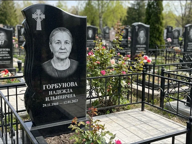 Памятник из чёрного гранита — высокий обелиск с кельтским крестом, работа «Одинцова» в Томске