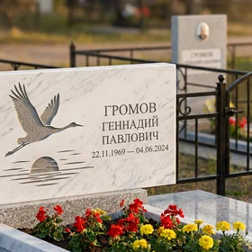 Мраморный памятник с журавлями и портретом